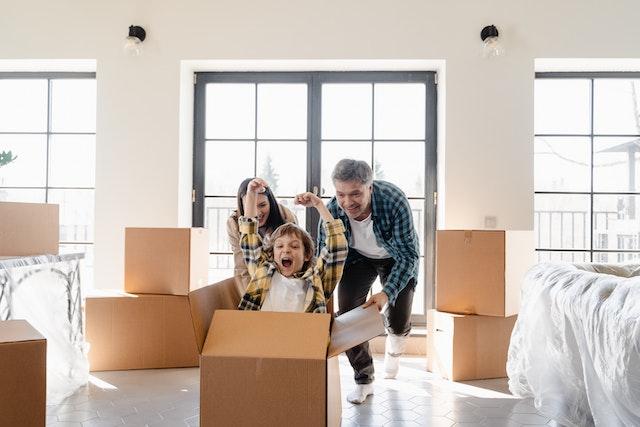 Parents navigating screen time concerns by playing with their son while packing.