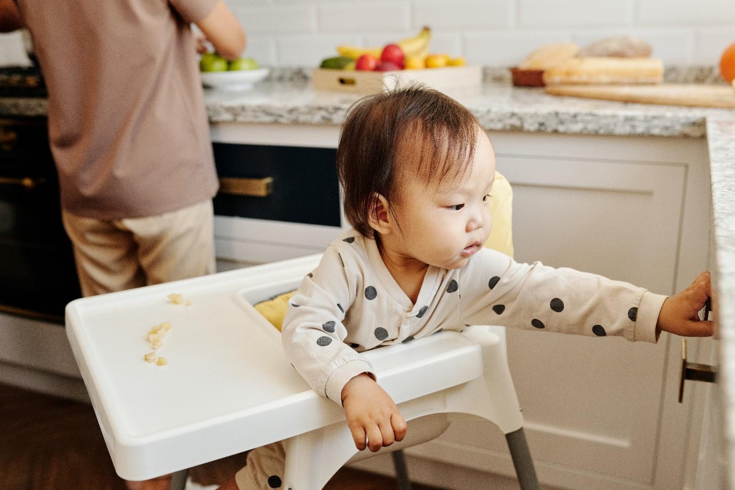 toddler reaching for a drawer in the kitchen.
